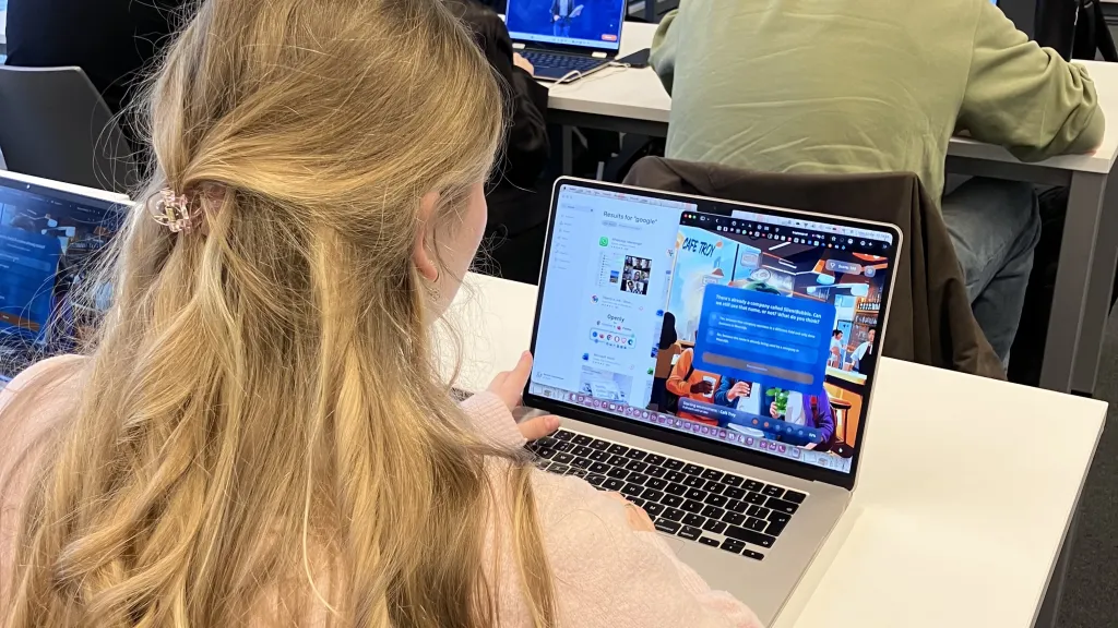 Vrouw speelt game Troy Tower op laptop.