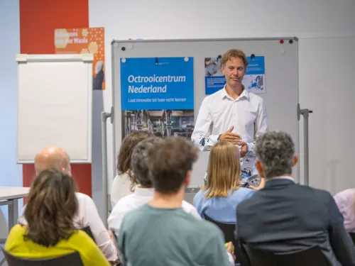 Adviseur staat voor groep mensen bij workshop