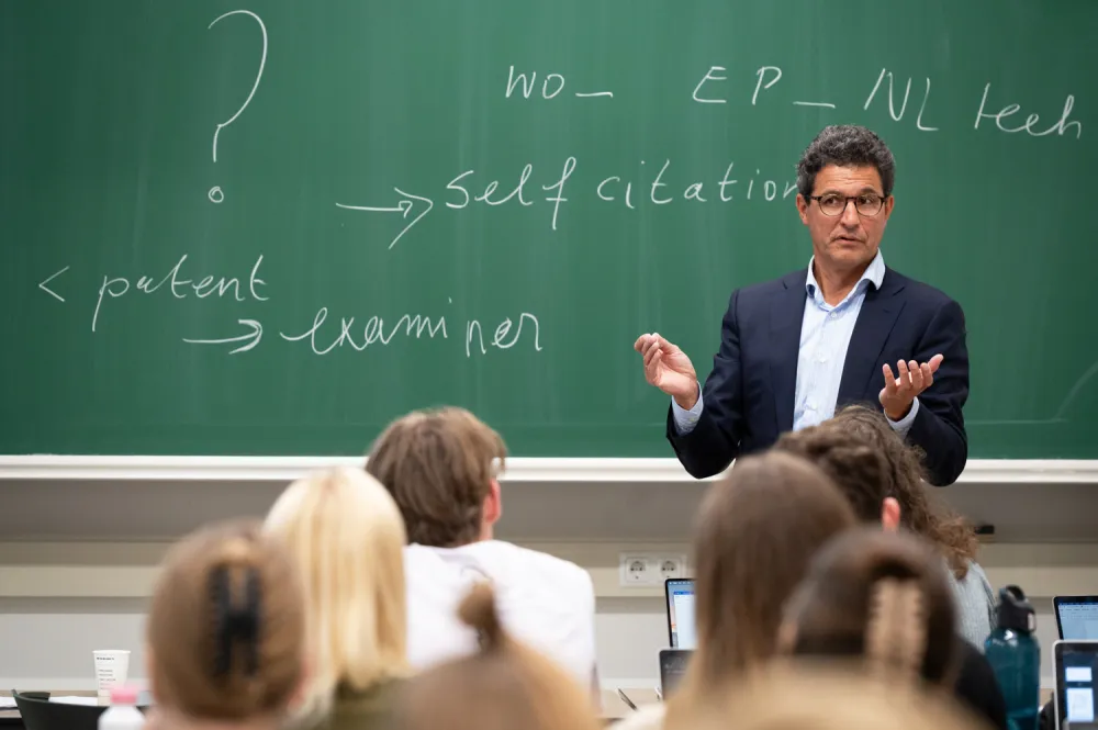 Docent voor schoolbord met vraagteken erop.